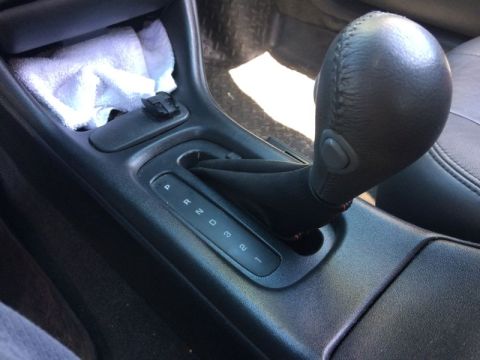 2002 Pontiac Grand Prix - The interior of a car shows a close-up of the automatic gear shifter. The shifter is in the 'P' (Park) position, with 'R', 'N', 'D', '3', a…