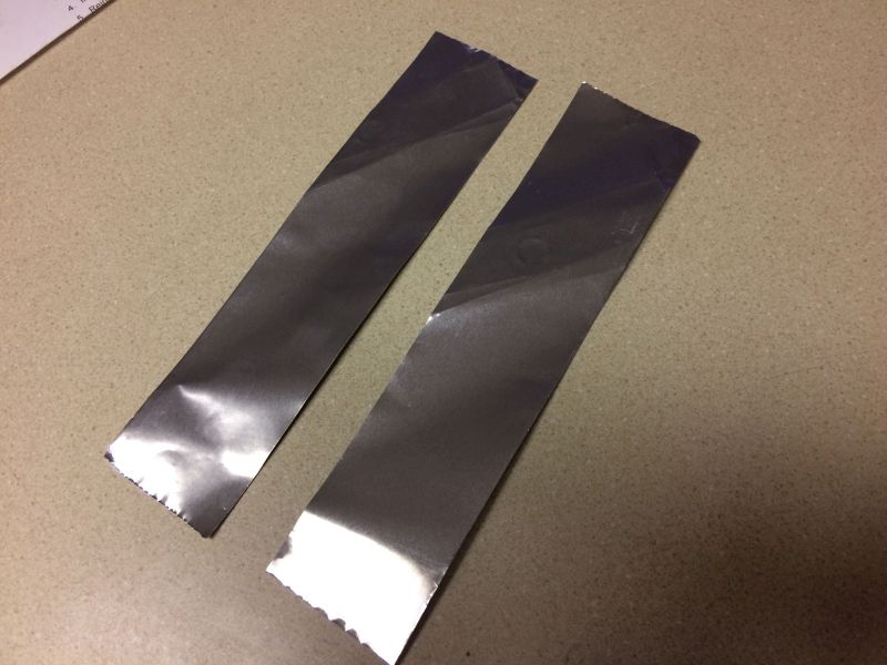 Two strips of metallic material on a speckled countertop.