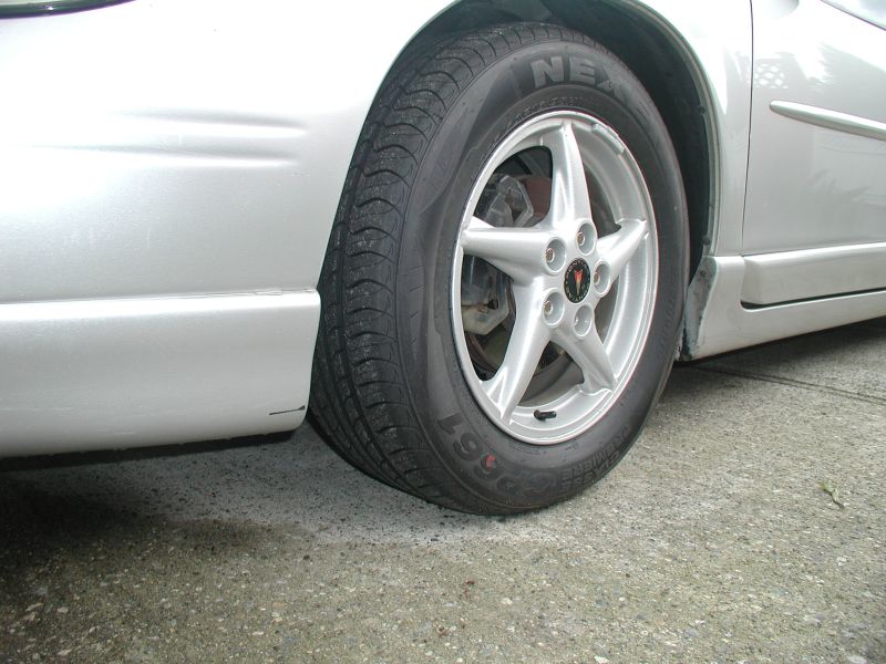Silver Pontiac Grand Prix front passenger wheel and fender