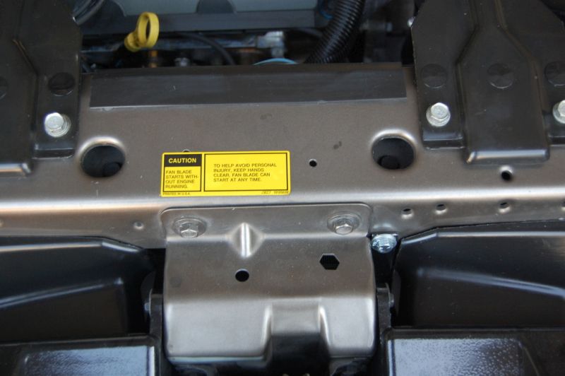 Yellow caution sticker on vehicle engine bay: Fan blade starts with engine running.