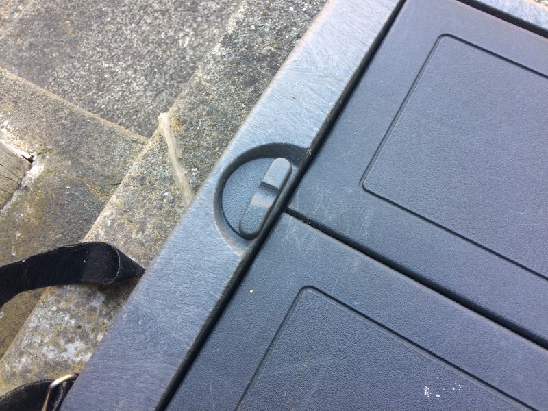 Close-up of a black plastic case with a strap on concrete steps.