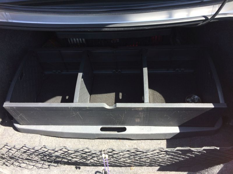 Trunk organizer with three compartments in a vehicle trunk