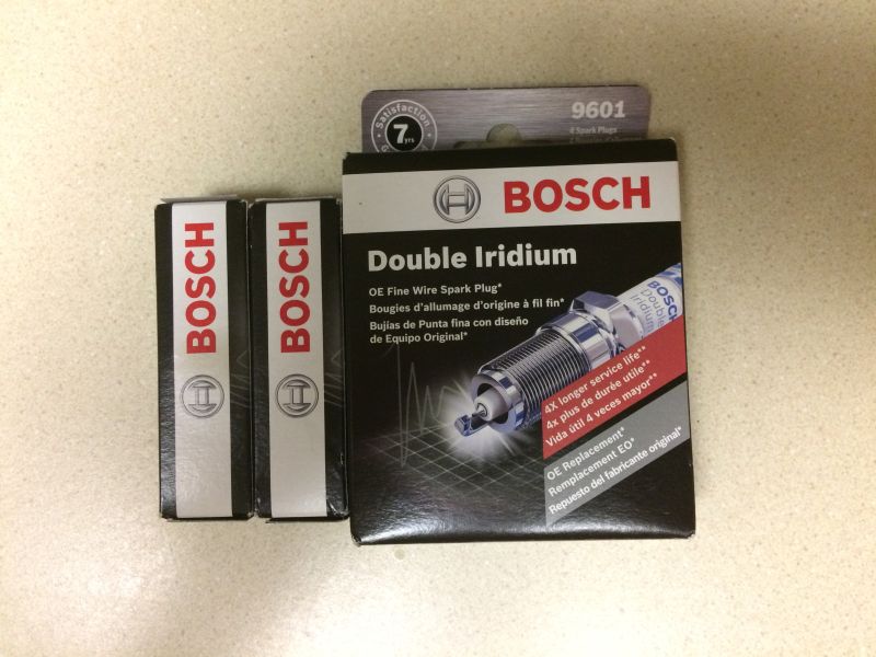 Two Bosch spark plug boxes next to a larger Bosch spark plug box.