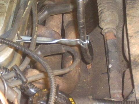 1991 Ford LTD Crown Victoria - A detailed view of various engine components, including hoses and exhaust parts, within a vehicle.