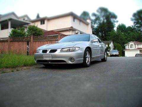 Silver 2002 Pontiac Grand Prix sedan parked on a suburban street.