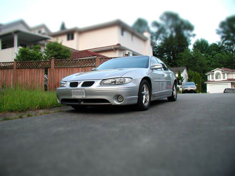 Silver 2002 Pontiac Grand Prix sedan parked on a suburban street.