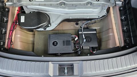 2026 Honda CR-V - Two black Motorola radio units are installed in the trunk of a vehicle, along with wiring and a black speaker enclosure.