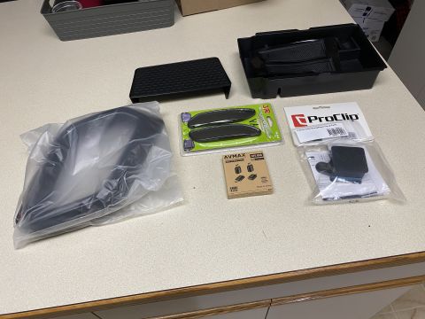 2026 Honda CR-V - A collection of car accessories are laid out on a countertop. Items include a black organizer tray, a black plastic car part in a plastic b…