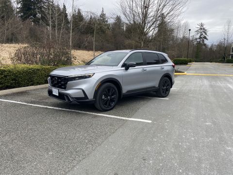2026 Honda CR-V - A silver Honda CR-V is parked in a parking lot with a wooded area in the background. The vehicle is shown from a 3/4 front angle.