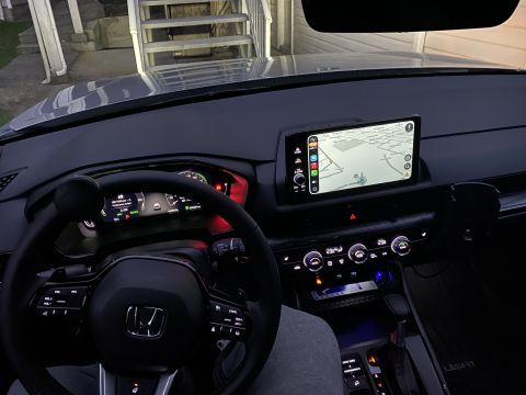 2026 Honda CR-V - Interior view of a modern car dashboard at night, showing a digital instrument cluster, a central infotainment screen displaying navigation…