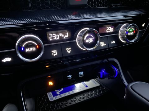 2026 Honda CR-V - The interior of a modern car's climate control panel is shown, featuring illuminated digital displays for temperature and illuminated knobs…