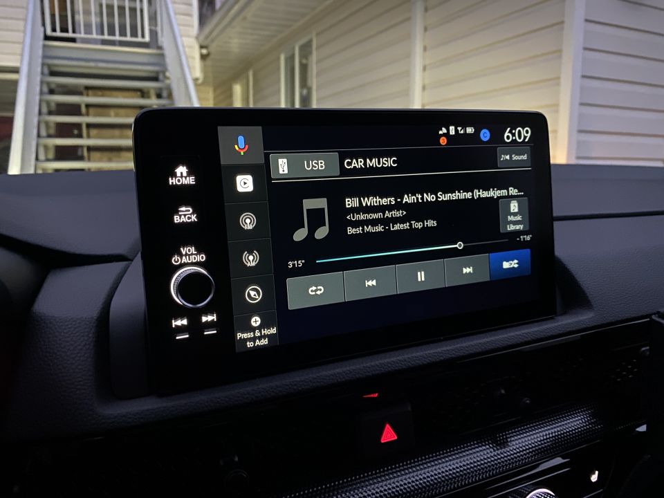 Car infotainment screen showing music playback controls and song title.