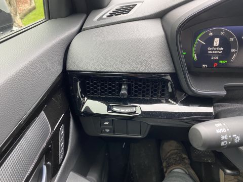 2026 Honda CR-V - Interior view of a modern car's dashboard, focusing on the driver's side air vent, digital instrument cluster, and steering wheel controls.…