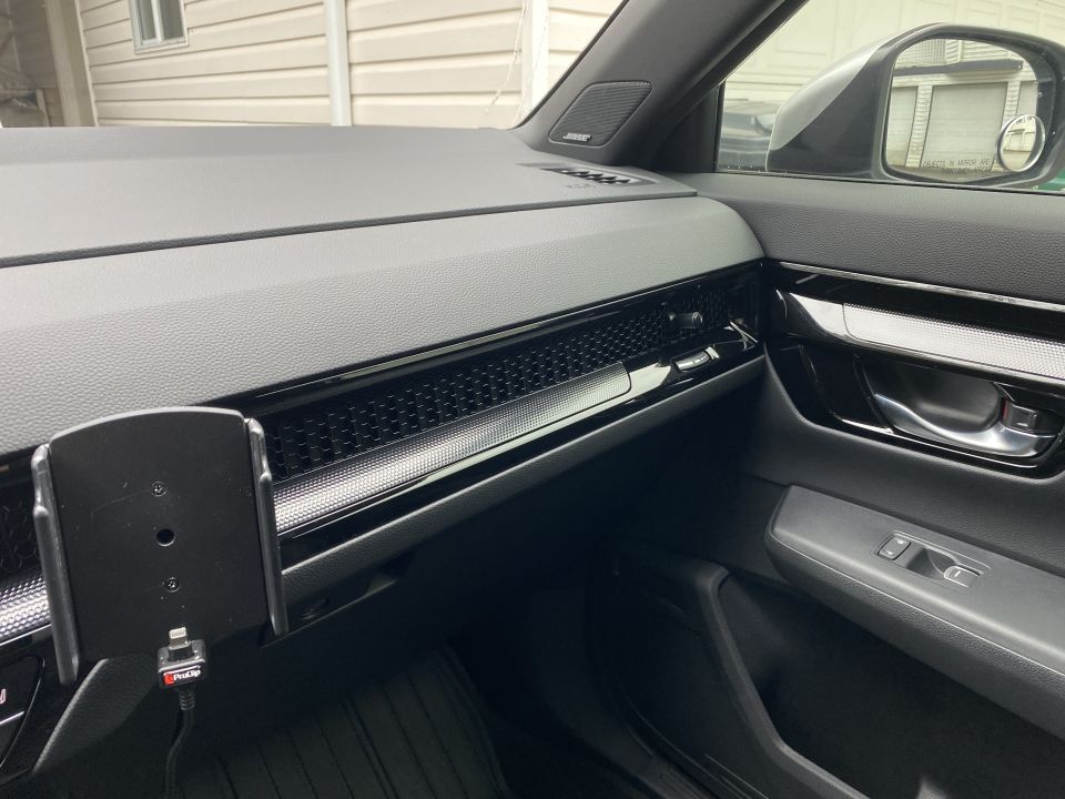 Car interior dashboard with phone mount and charging cable.