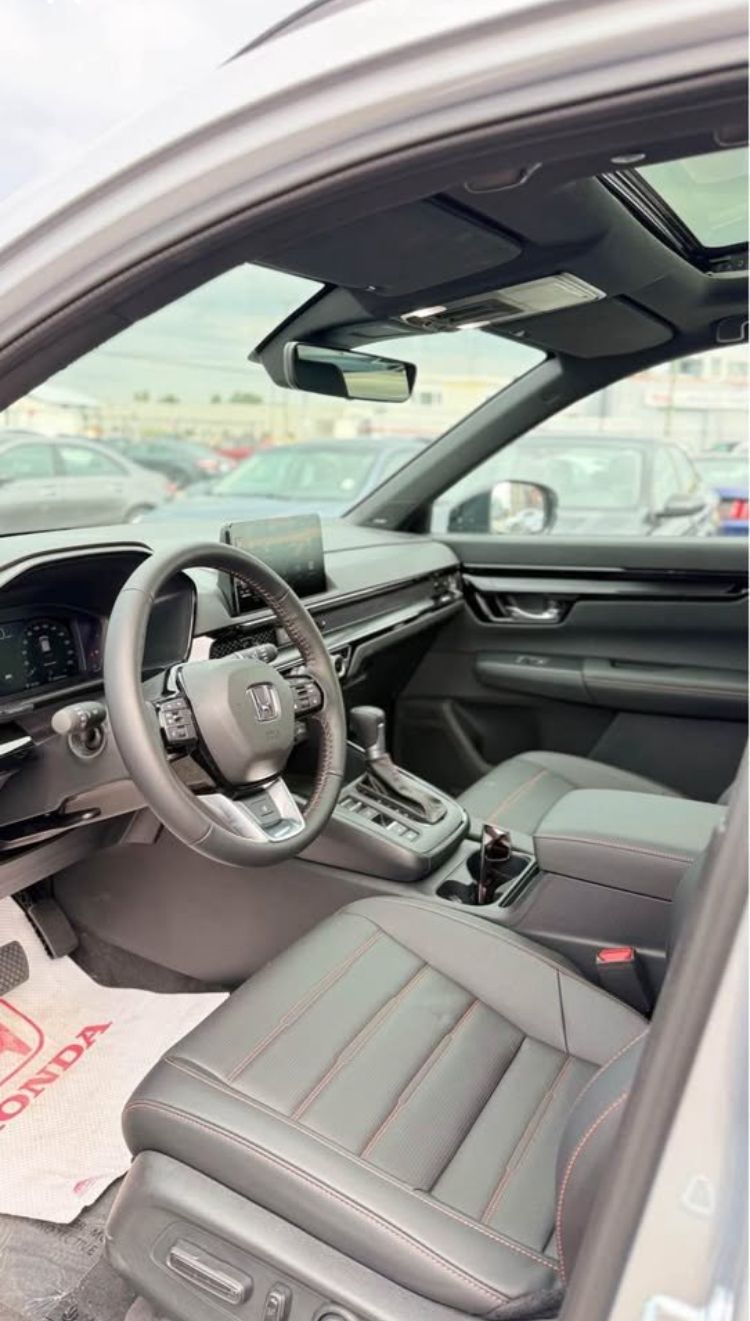 Interior view of a modern black leather SUV with red stitching, digital dashboard, and infotainment screen.