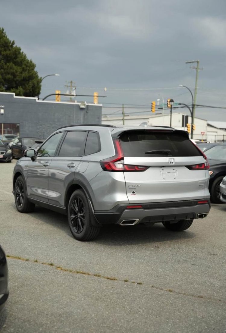 Silver Honda CR-V parked in an asphalt lot, rear passenger side view.