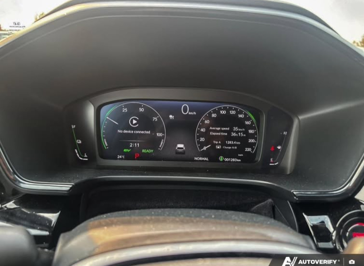 Digital dashboard of a car showing speed, trip meter, and battery status.