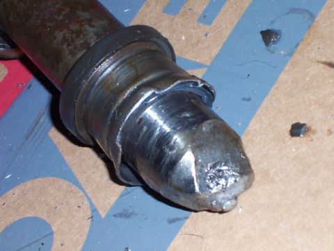 2000 Ford F-450 - Close-up view of a damaged metal part, possibly a shaft, showing signs of impact and wear.