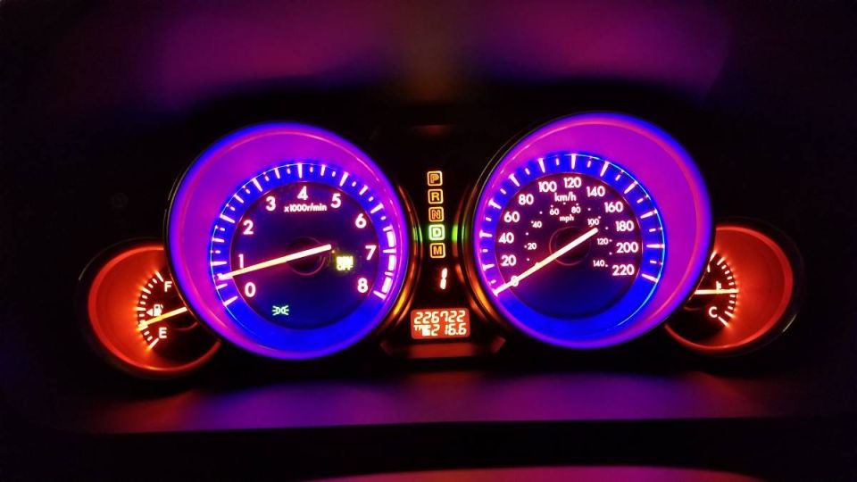 2009 Mazda CX-9 dashboard gauges lit up with purple and blue lights.