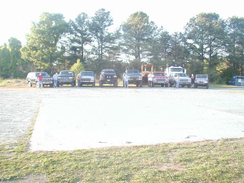 1988 Ford Bronco - A group of SUVs and trucks are parked in a lot on a sunny day.