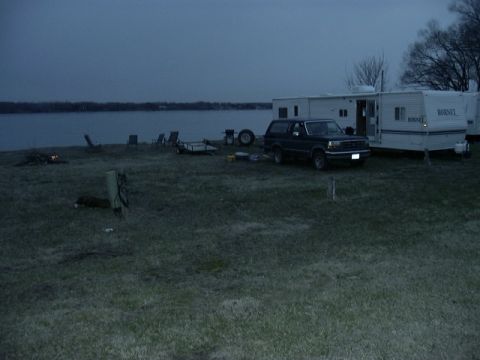 1992 Ford Bronco - 1992 Ford Bronco parked at a campsite next to RVs by a body of water.