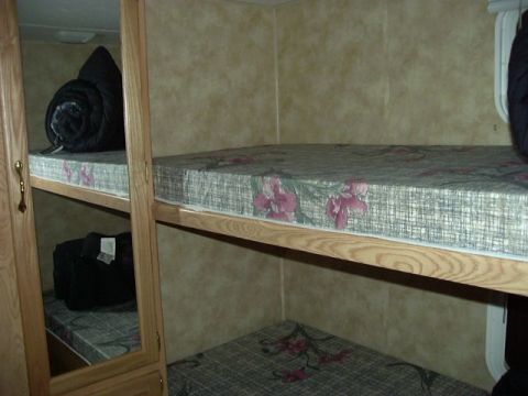 1992 Ford Bronco - Interior view of bunk beds in an RV, showing mattresses and bedding.