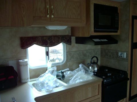 1992 Ford Bronco - Interior view of an RV kitchen showing the sink, stove, and microwave.