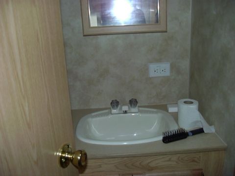 1992 Ford Bronco - Interior view of a bathroom sink area, showing a sink, faucet, toilet paper, and hairbrush.