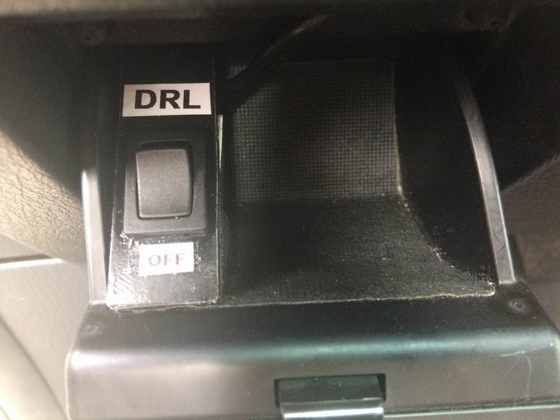 DRL switch labeled 'OFF' inside a vehicle.