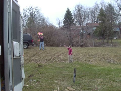 1992 Ford Bronco - A black SUV is visible in the background of a rural scene with two people playing frisbee.