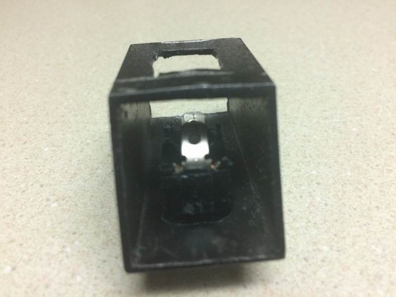 Black metal component with internal silver mechanism and copper wires.
