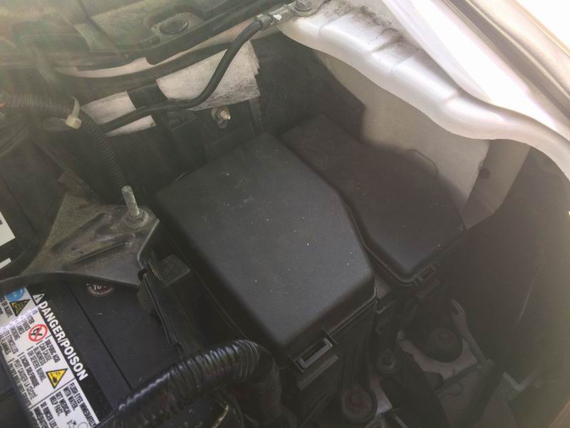 2009 Mazda CX-9 engine bay showing fuse box and battery.