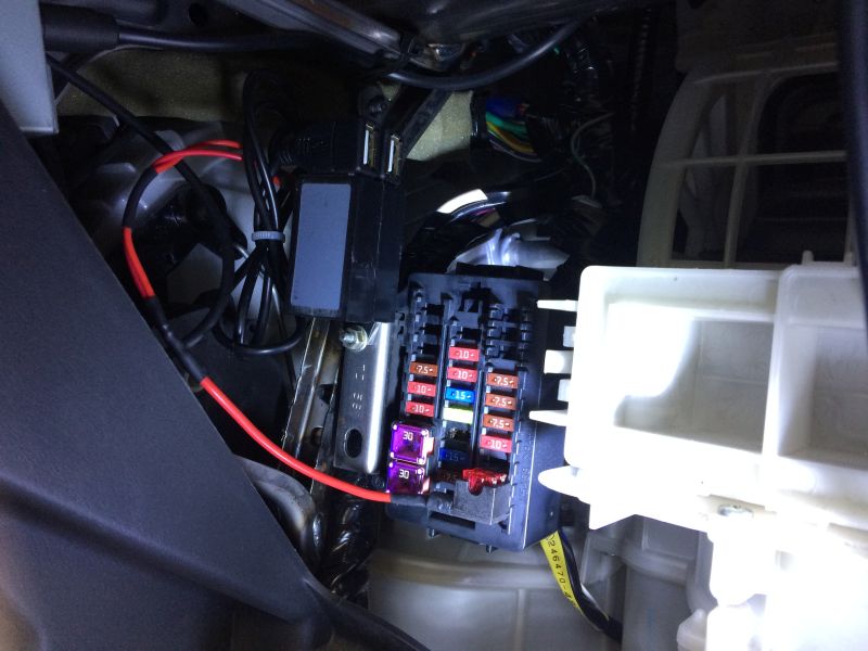 Car fuse box with colorful fuses and wiring.