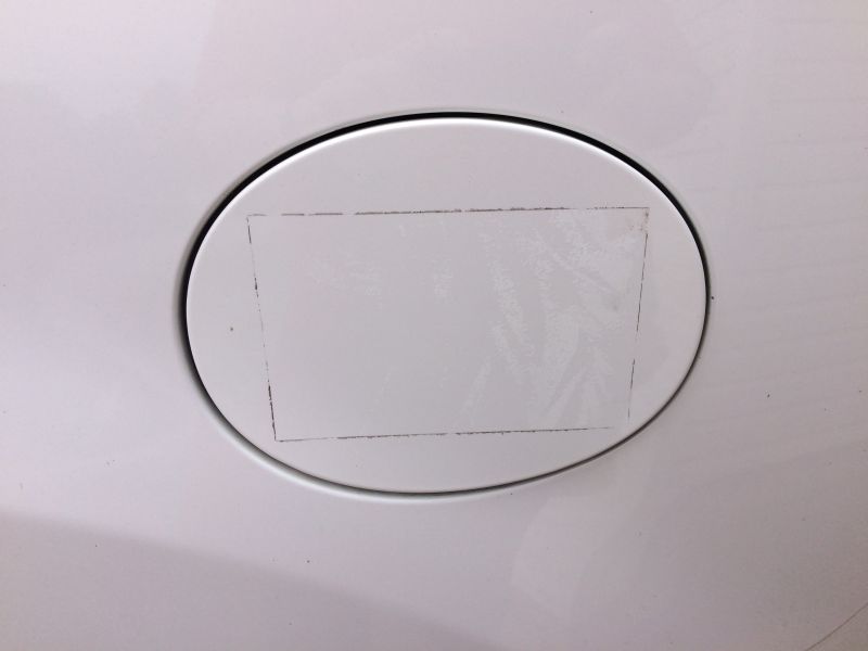 Sticker on the fuel door. Warmed up with a heat gun and pealed it off, then dhesive remover to clean up any residue, then a liquied clay bar, and finished off with some wax.