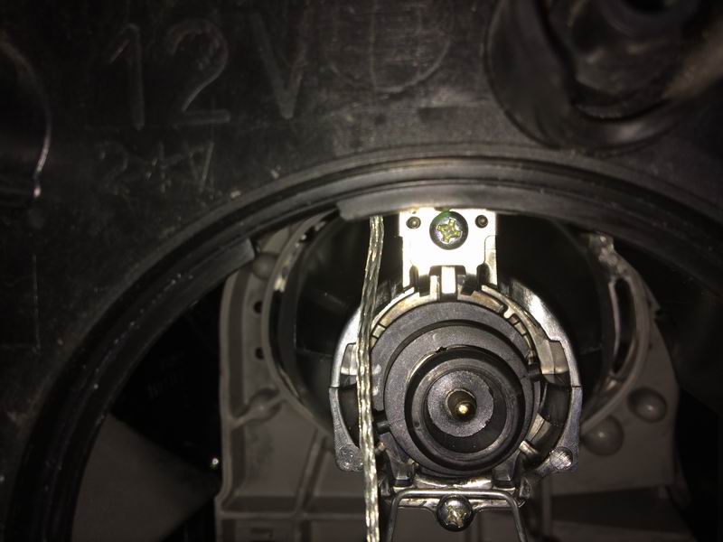 Left side: the low beam housing is right next to the fender. Twist off the weather cap, twist off the electrical connector, unclip the two bulb retainer arms (push in each arm so it can move outwards), pivot the retainer downwards and pull the bulb out.