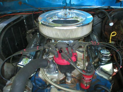 1978 Ford Bronco - Top-down view of a V8 in a blue truck's engine bay wearing a chrome-topped round air cleaner with white paper element, a red distributor ca…