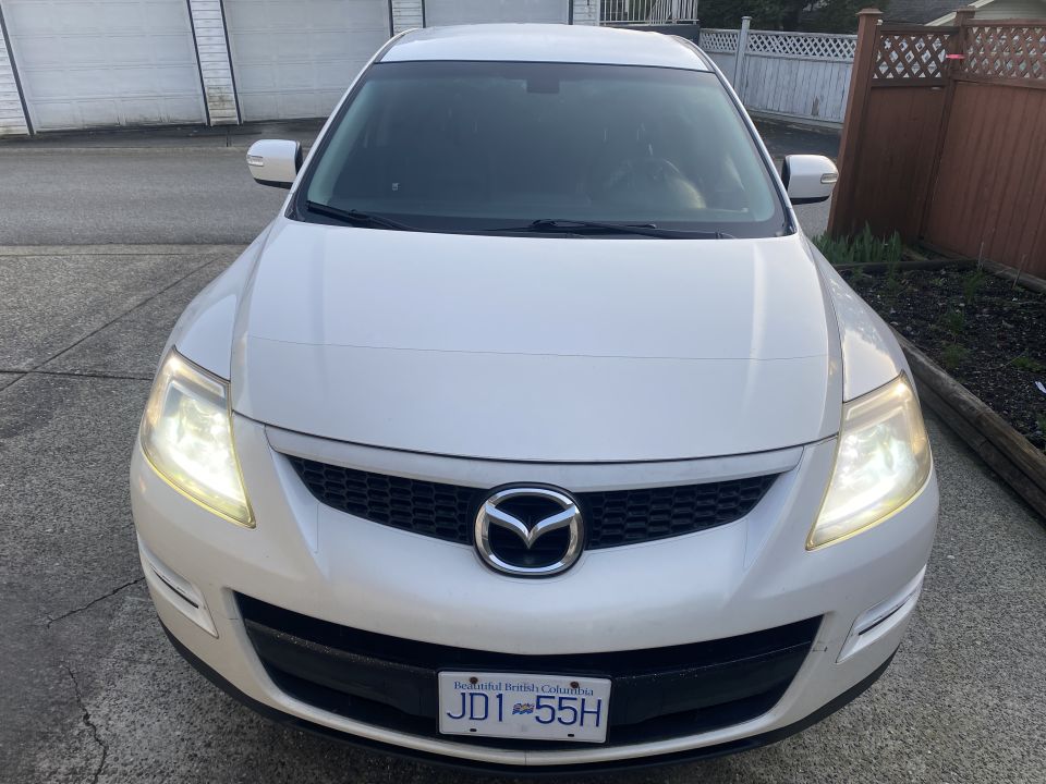 White 2009 Mazda CX-9 front view, headlights on, BC license plate JDT 55H
