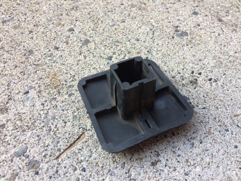 Black plastic hitch receiver cover on concrete