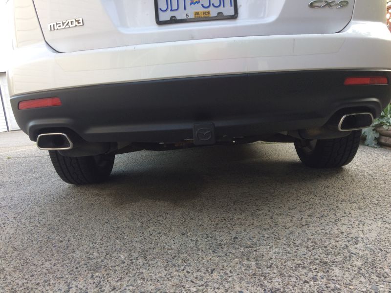 Rear view of a white Mazda CX-9 SUV with dual exhaust and trailer hitch