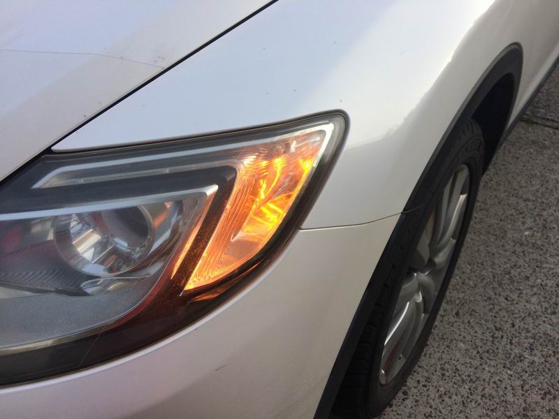 White SUV passenger side headlight and wheel