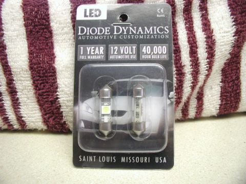2009 Mazda CX-9 - A package of Diode Dynamics LED bulbs for automotive use is displayed against a striped towel. The packaging highlights a 1-year full warra…
