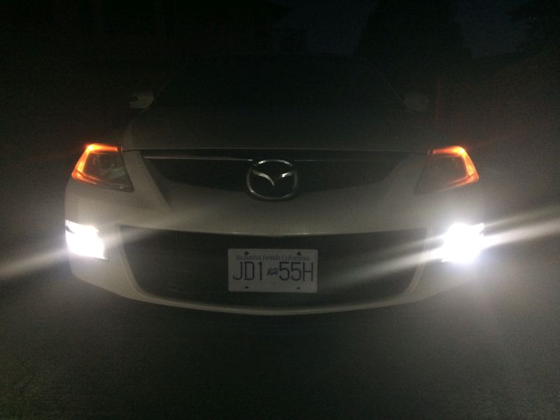 White 2009 Mazda CX-9 front view at night, headlights on, license plate JD1 55H.