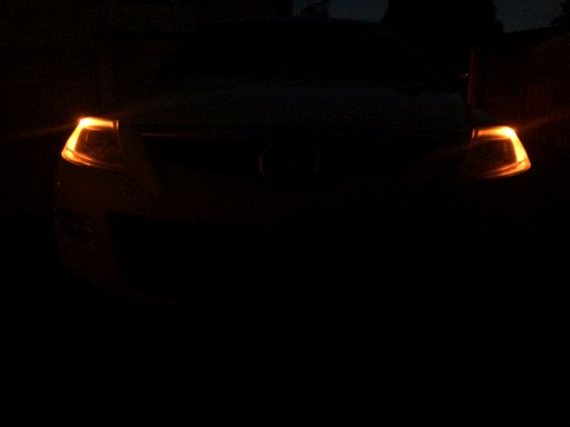 Front view of a dark SUV at night with illuminated amber turn signals.