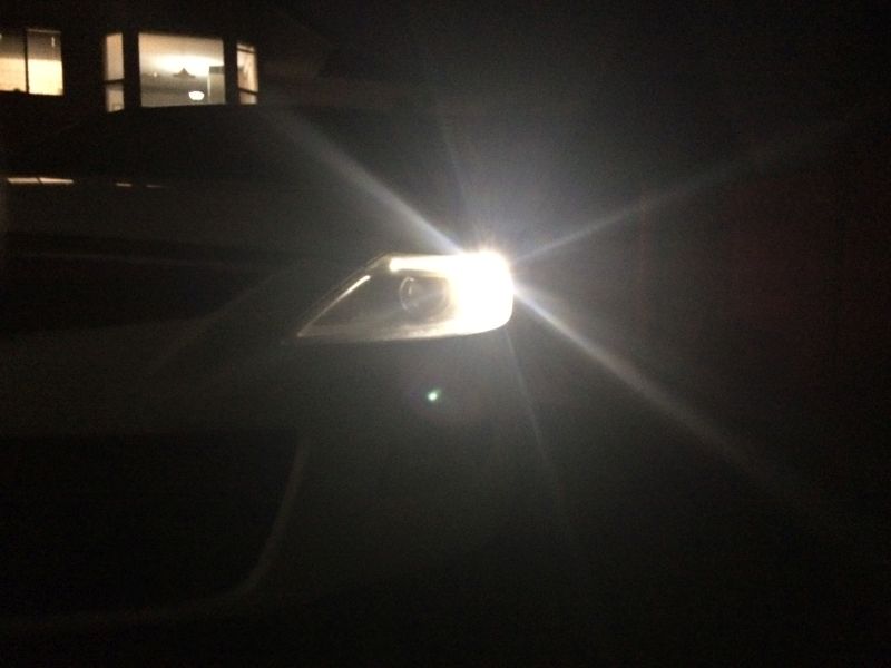 Close-up of a car headlight at night.