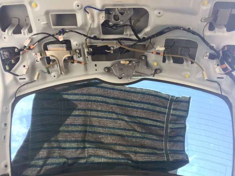 Interior of a vehicle tailgate with wiring and rear window