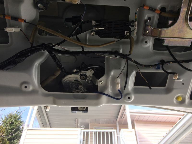 Interior of a car trunk lid showing wiring and liftgate actuator.