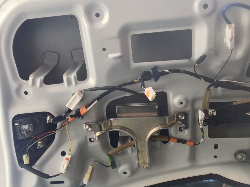Interior of a car's rear door panel showing wiring and latch mechanism.