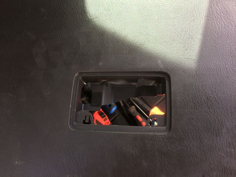 Broken black plastic trim with visible orange and blue electrical connector.