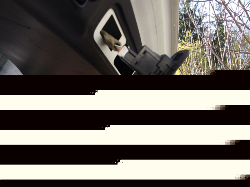 Close-up of a black electrical connector with wires plugged into a white housing