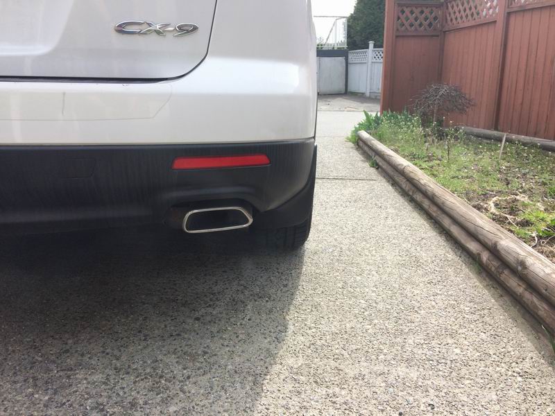 Rear view of a white Mazda CX-9 showing exhaust pipe and bumper.